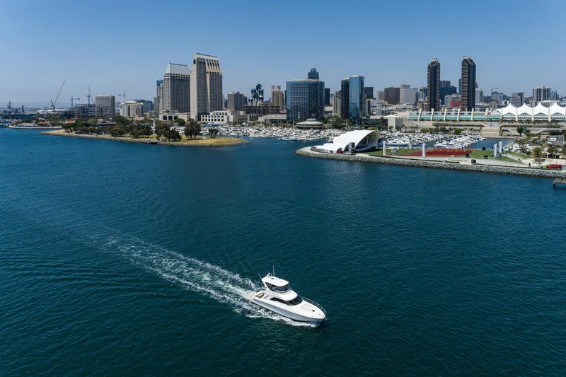Slide: The Image of A 2001 Sea Ray 560 Sedan Bridge yacht cruising near a city skyline. - 20