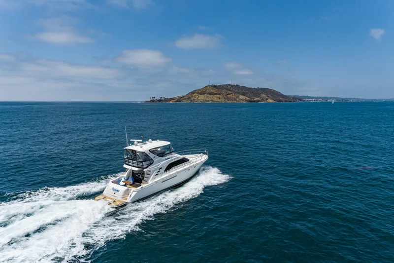Slide: The Image of 2001 Sea Ray 560 Sedan Bridge cruising on open water near an island. - 22