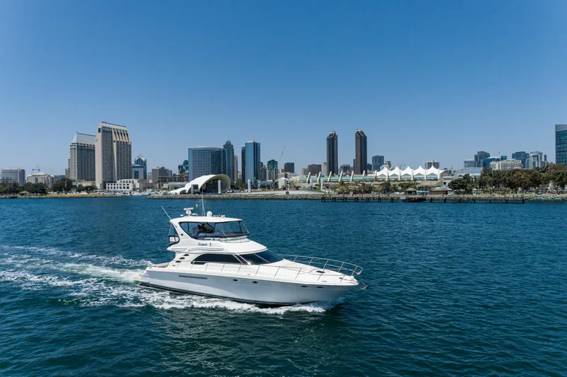 Slide: The Image of 2001 Sea Ray 560 Sedan Bridge yacht cruising near city skyline. - 25