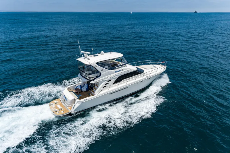 Slide: The Image of 2001 Sea Ray 560 Sedan Bridge yacht cruising on open ocean waters. - 27
