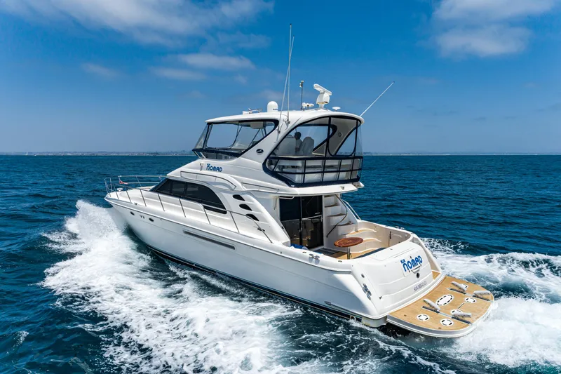 Slide: The Image of 2001 Sea Ray 560 Sedan Bridge yacht cruising on open ocean under clear blue sky. - 28