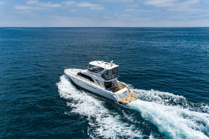 Slide: The Image of 2001 Sea Ray 560 Sedan Bridge yacht cruising on open ocean waters. - 29