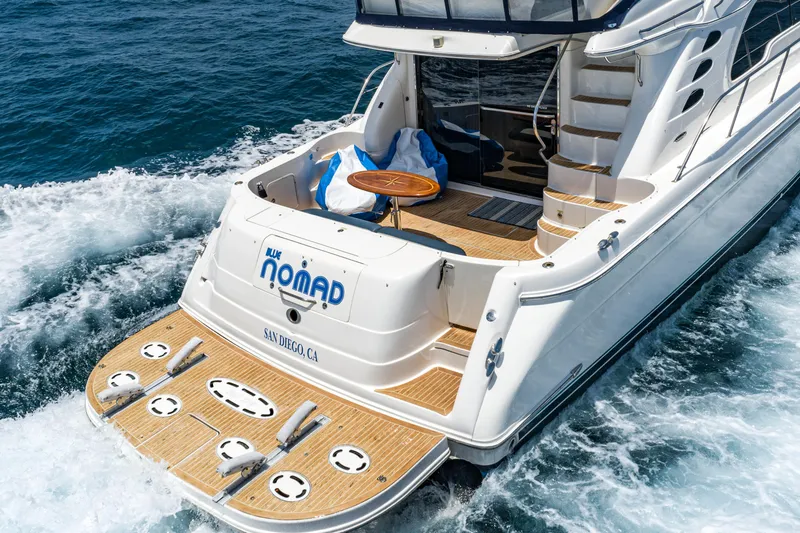 Slide: The Image of 2001 Sea Ray 560 Sedan Bridge yacht cruising on ocean waters, rear view. - 32