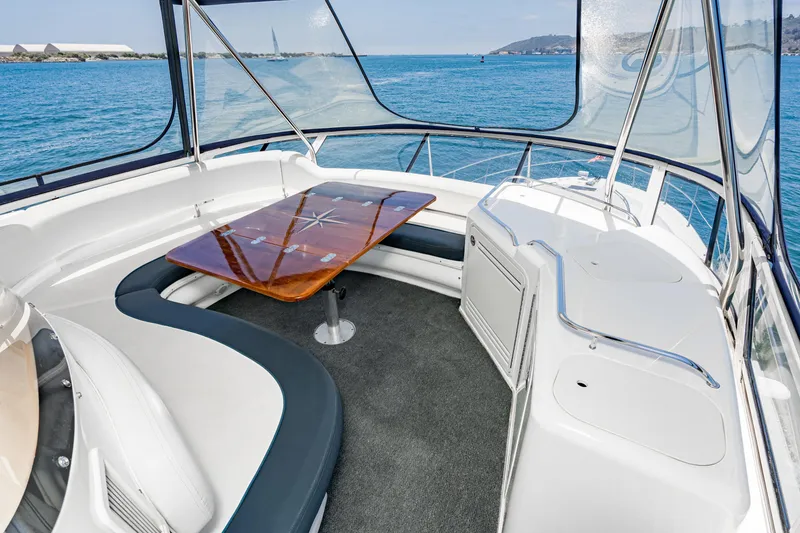 Slide: The Image of 2001 Sea Ray 560 Sedan Bridge yacht interior with seating and table, overlooking ocean. - 41