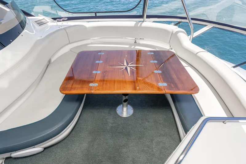 Slide: The Image of Luxurious seating area on 2001 Sea Ray 560 Sedan Bridge yacht with wooden table. - 42