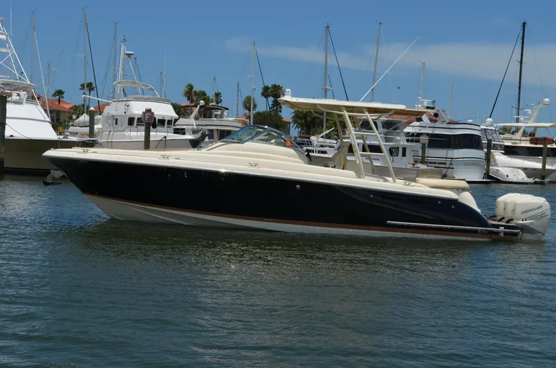 The Image of 2016 Chris-Craft Launch 36 boat docked in a marina, surrounded by other vessels. - 0