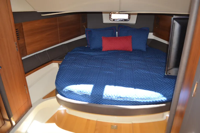 Slide: The Image of 2016 Chris-Craft Launch 36 cabin with blue bedding and wooden interior. - 10