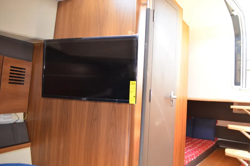 Slide: The Image of 2016 Chris-Craft Launch 36 interior with TV, wood paneling, and cozy seating area. - 11