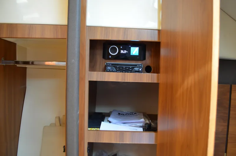 Slide: The Image of 2016 Chris-Craft Launch 36 interior with wooden shelving and audio system. - 13