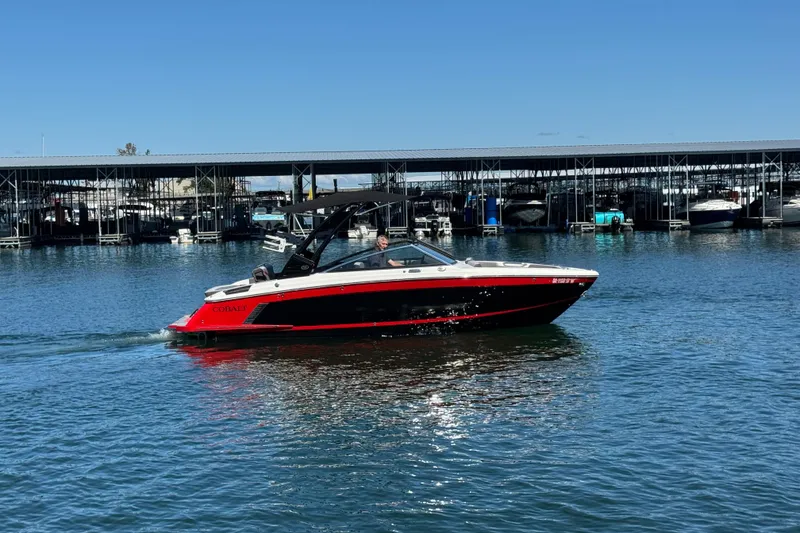 The Image of 2023 Cobalt R4 Surf boat cruising on a sunny day near a marina. - 0