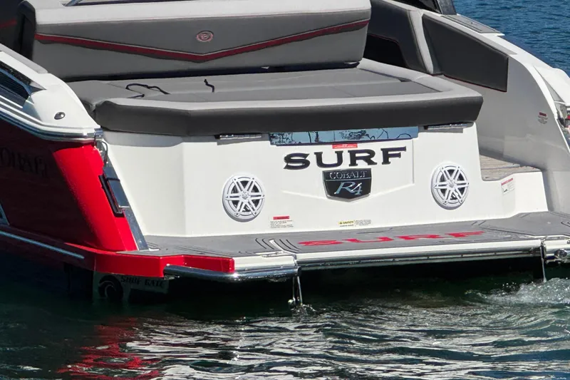 Slide: The Image of 2023 Cobalt R4 Surf boat rear view with branding and water backdrop. - 12