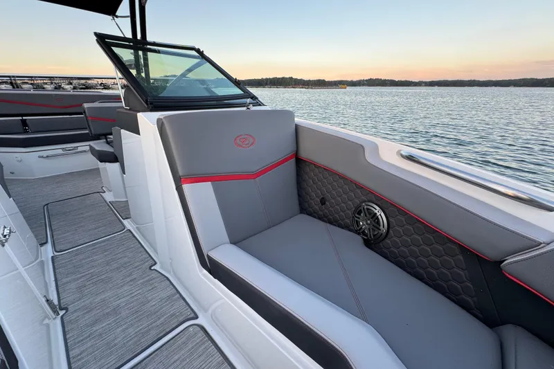 Slide: The Image of 2023 Cobalt R4 Surf boat interior with gray seating and lake view at sunset. - 15
