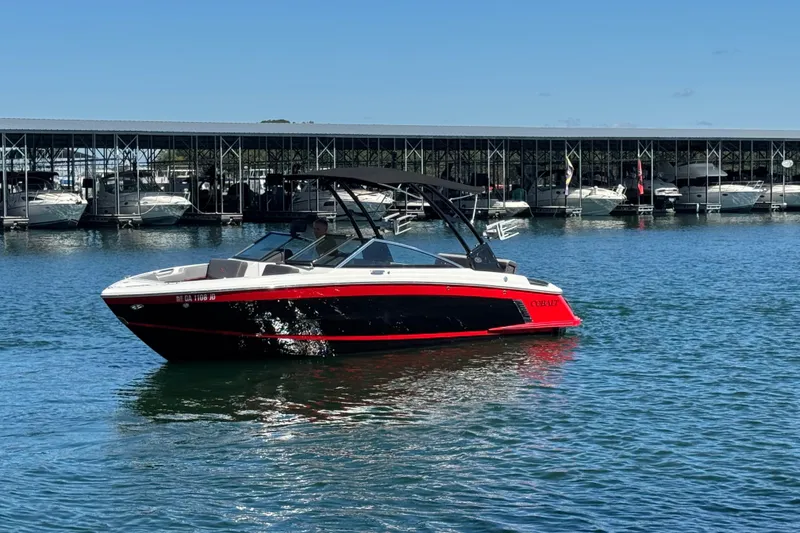 Slide: The Image of 2023 Cobalt R4 Surf boat on water near marina, sunny day. - 8