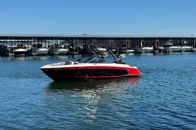 Slide: The Image of 2023 Cobalt R4 Surf boat on calm water near marina. - 9