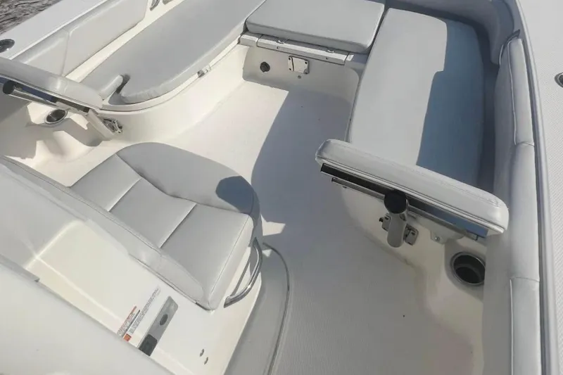 Slide: The Image of 2017 Robalo 246 Cayman boat interior with cushioned seating and rod holders. - 10