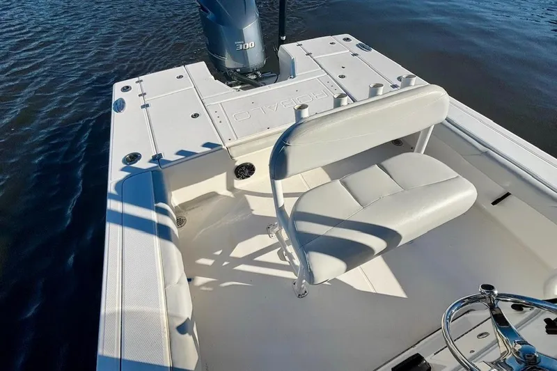 Slide: The Image of 2017 Robalo 246 Cayman boat interior with seating and motor on water. - 12