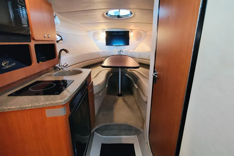 Slide: The Image of Cabin interior with kitchenette, seating, and table that converts to a queen-size bed. - 14