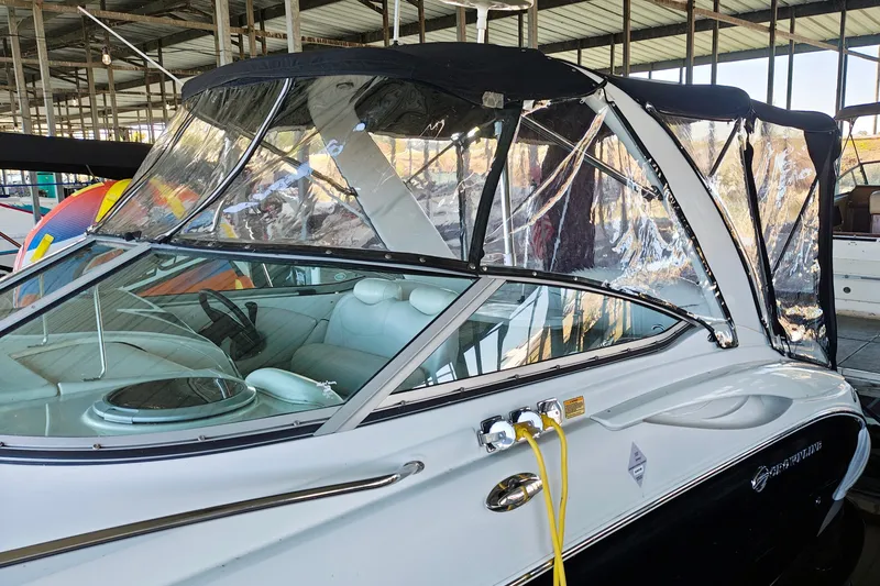 Slide: The Image of 2004 Crownline 270 CR boat with clear canopy in a marina setting. - 21