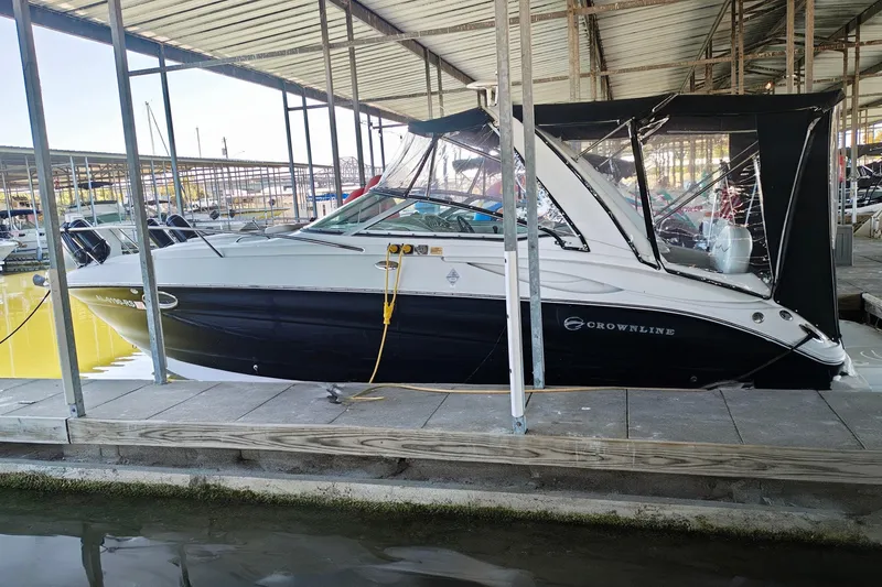 Slide: The Image of 2004 Crownline 270 CR boat docked in a marina under a covered shelter. - 23