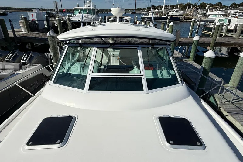 Slide: The Image of 2003 Tiara Yachts 3500 Open docked at marina, showcasing sleek design and spacious deck. - 11