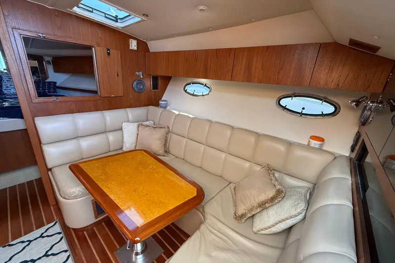 Slide: The Image of 2003 Tiara Yachts 3500 Open interior with beige seating and wooden accents. - 24