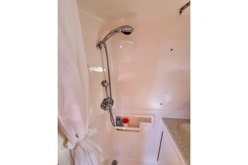 Slide: The Image of Shower area in 2003 Tiara Yachts 3500 Open, featuring chrome fixtures and storage shelf. - 29