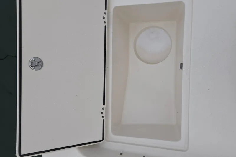 Slide: The Image of 2021 Carolina Skiff 19 LS dry storage compartment with port open hatch, showcasing interior space.Molded in 5-gallon bucket storage - 20