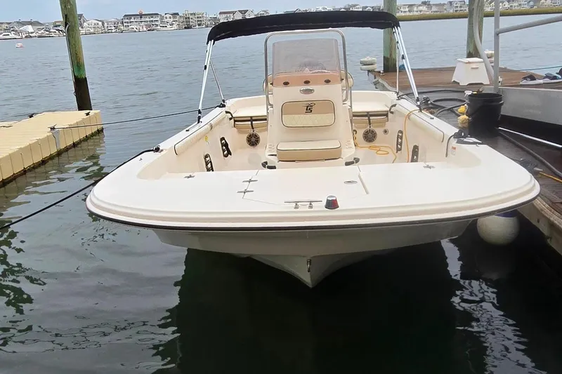Slide: The Image of 2021 Carolina Skiff 19 LS boat docked, featuring seating and outboard motor. Aft foldable seats in their upright position. - 5