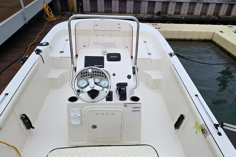 Slide: The Image of 2021 Carolina Skiff 19 LS boat interior with steering console and seating at dock. - 7