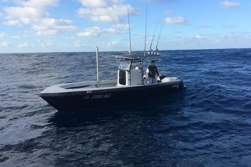 The Image of 2004 SeaVee Center Console boat on open ocean, person fishing under clear sky. - 1