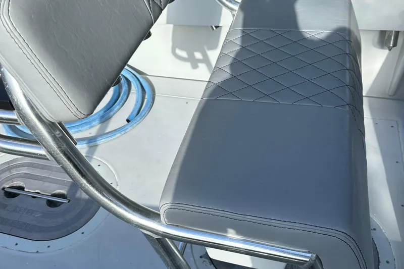Slide: The Image of 2004 SeaVee Center Console boat seat with quilted gray upholstery and metal frame. - 15