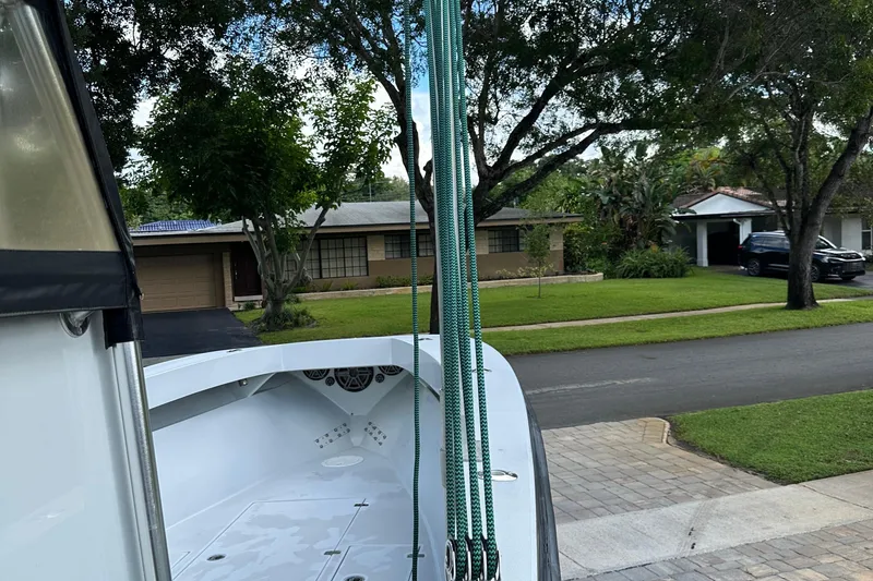 Slide: The Image of 2004 SeaVee Center Console boat parked in a suburban driveway, surrounded by trees and houses. - 17