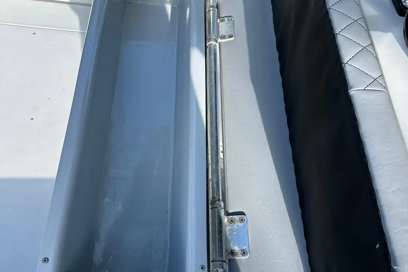 Slide: The Image of 2004 SeaVee Center Console boat interior with storage compartment and cushioned seating. - 27