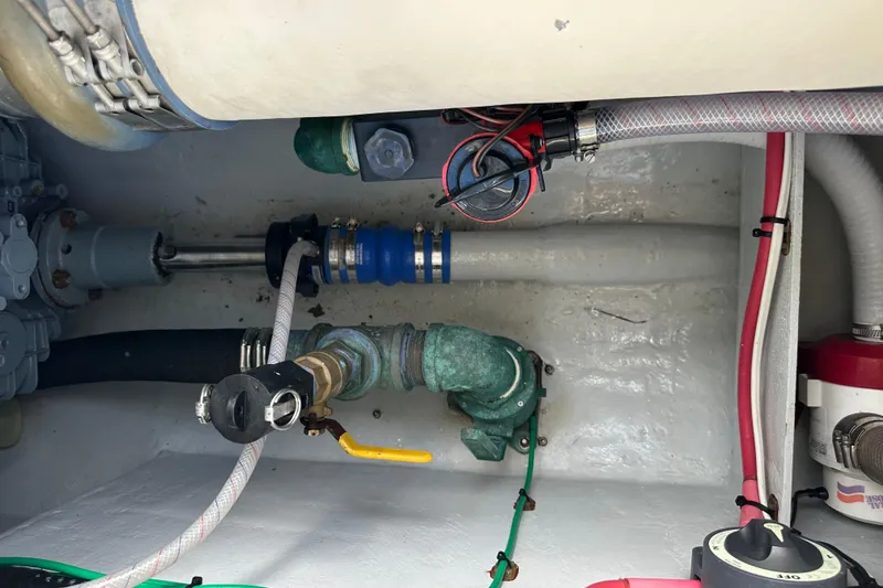 Slide: The Image of Engine compartment of a 2004 SeaVee Center Console boat, showing pipes and valves. - 32