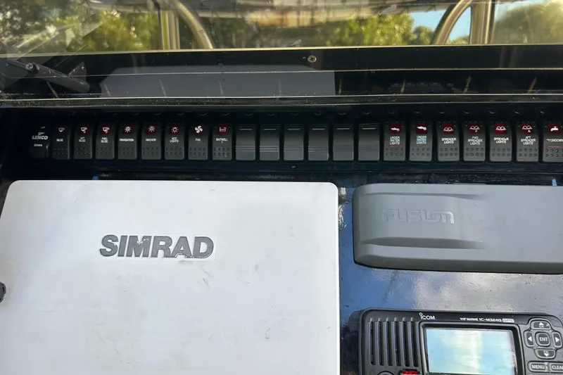 Slide: The Image of 2004 SeaVee Center Console dashboard with Simrad and Fusion equipment, featuring various control switches. - 34