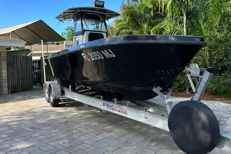 Slide: The Image of 2004 SeaVee Center Console boat on trailer, parked in driveway with tropical background. - 4