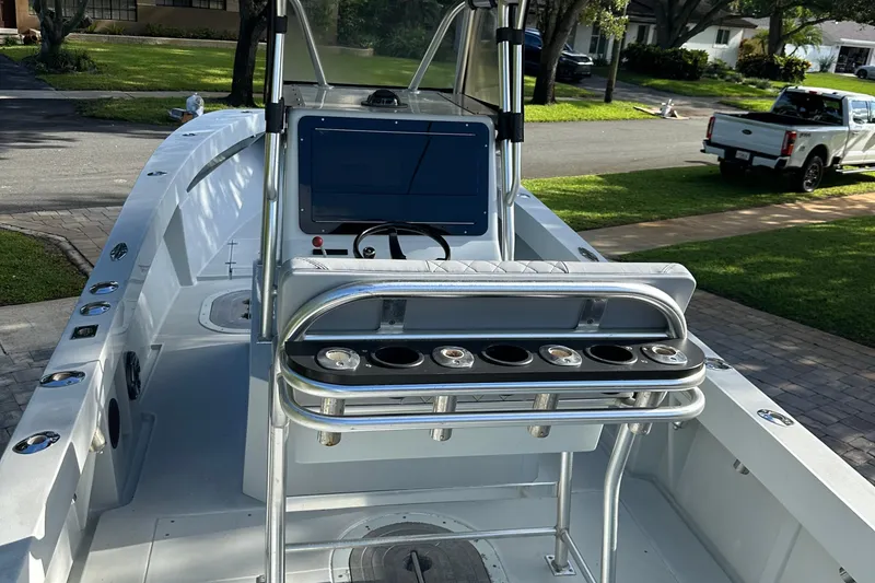 Slide: The Image of 2004 SeaVee Center Console boat with modern helm and rod holders, parked in a residential area. - 9