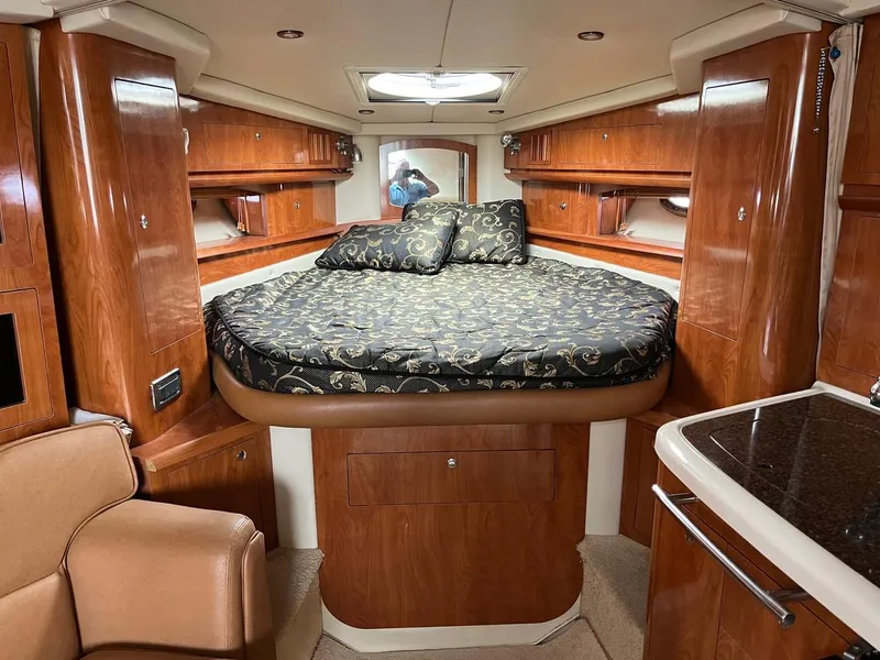 Slide: The Image of 2006 Four Winns 348 Vista boat interior with cushioned seating and wooden table. - 11