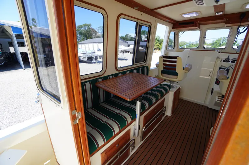 Slide: The Image of 2016 Rosborough 246 Dingby interior with striped seating, wooden table, and helm station. - 15