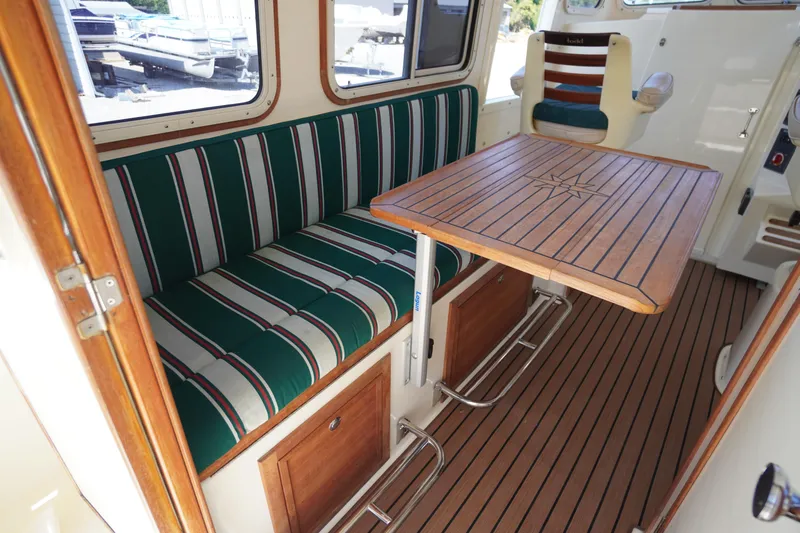 Slide: The Image of 2016 Rosborough 246 Dingby interior with striped seating and wooden table. - 16