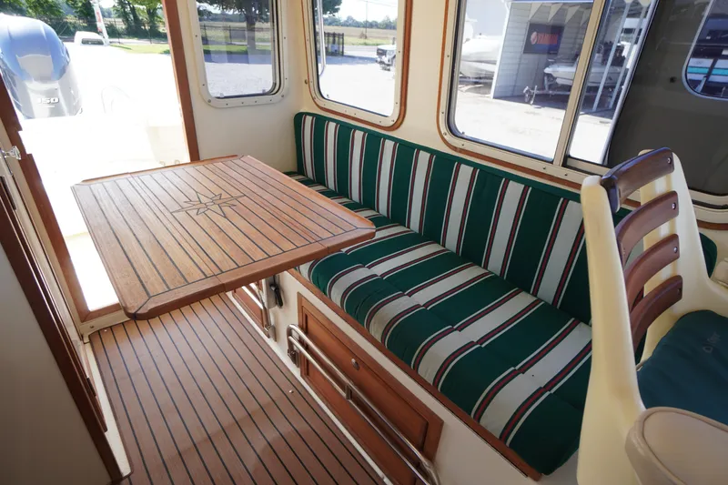 Slide: The Image of 2016 Rosborough 246 Dingby interior with striped seating and wooden table. - 17