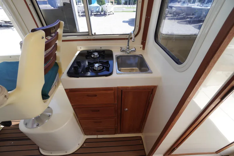 Slide: The Image of 2016 Rosborough 246 Dingby interior with compact kitchen, stove, sink, and seating. - 19