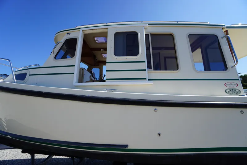 Slide: The Image of 2016 Rosborough 246 Dingby boat with white exterior and green accents under clear blue sky. - 2