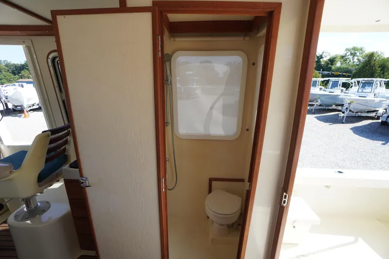 Slide: The Image of Interior of 2016 Rosborough 246 Dingby boat showing compact bathroom with toilet and window. - 23