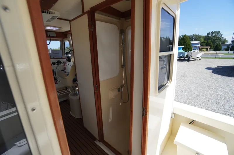 Slide: The Image of Interior of 2016 Rosborough 246 Dingby boat, featuring helm and shower area. - 25
