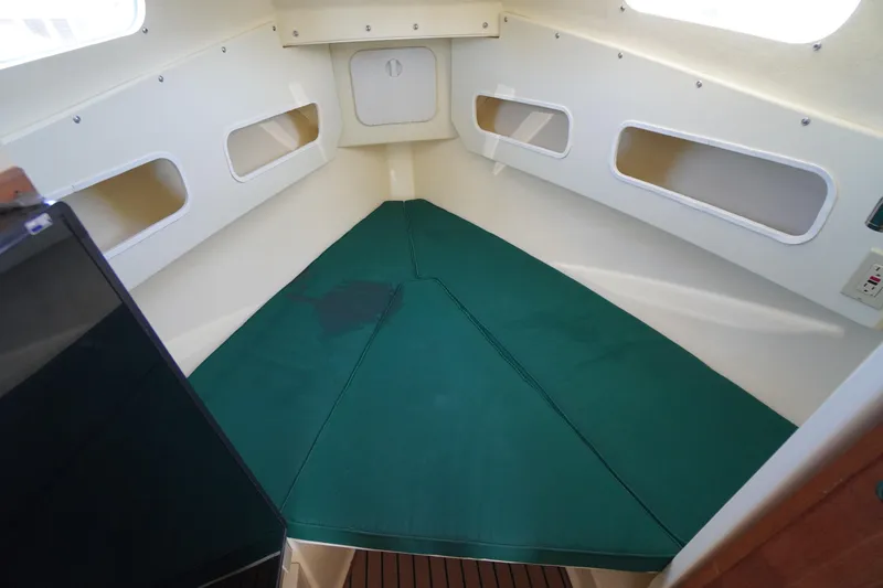Slide: The Image of 2016 Rosborough 246 Dingby boat interior with green cushioned sleeping area. - 27