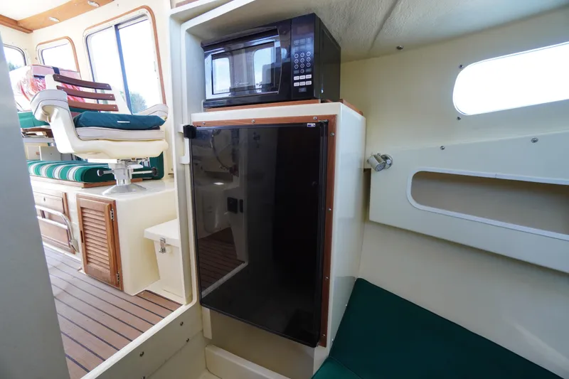 Slide: The Image of 2016 Rosborough 246 Dingby interior with microwave, fridge, and seating area. - 28