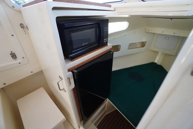 Slide: The Image of 2016 Rosborough 246 Dingby interior with microwave, fridge, and sleeping area. - 31