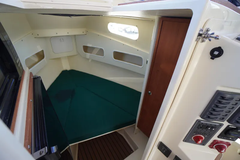 Slide: The Image of 2016 Rosborough 246 Dingby cabin interior with green cushions and control panel. - 32