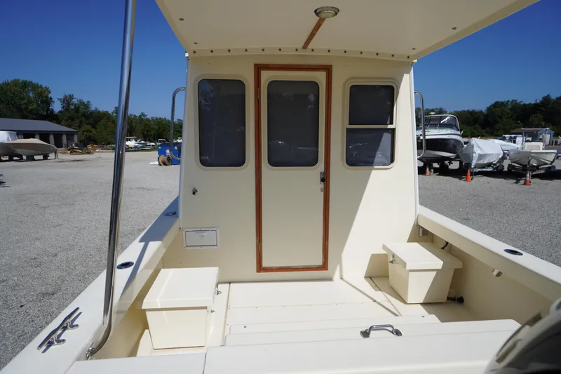 Slide: The Image of 2016 Rosborough 246 Dingby boat interior with seating and storage, parked outdoors. - 38